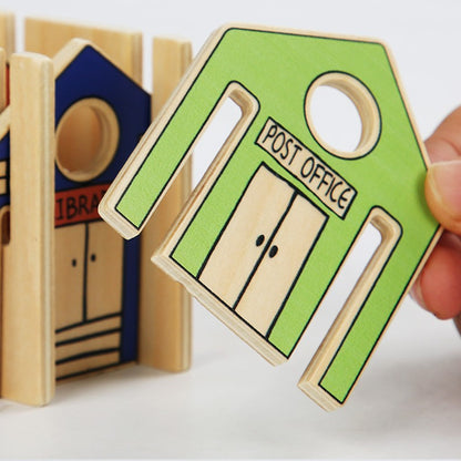 Wooden toy post office with a green door labeled 'Post Office' held by a hand.